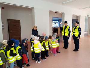 na zdjęciu znajdują się policjantki stojące przed grupą dzieci w budynku Przedszkola