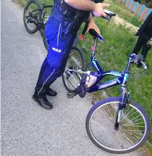 na zdjęciu widoczny jest umundurowany policjant trzymający rower