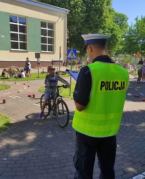 na zdjęciach widoczni są policjami umundurowani w odblaskowych kamizelkach oraz młodzież, która jeździ rowerem po torze sprawności