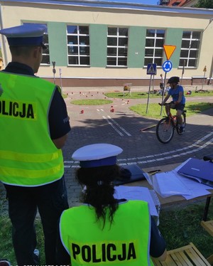 na zdjęciach widoczni są policjami umundurowani w odblaskowych kamizelkach oraz młodzież, która jeździ rowerem po torze sprawności