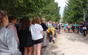 na zdjęciu znajduje się grupa młodzieży, przed którymi stoi policjantka