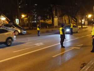 na zdjęciu są policjanci umundurowani, którzy na głównej ulicy w Giżycku zatrzymują do kontroli drogowej kierujących, sprawdzają ich stan trzeźwości