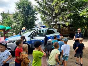 na zdjęciach znajdują się dzieci i ich opiekunowie oraz umundurowani policjanci przy oznakowanym radiowozie