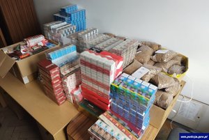 na zdjęciu widnieją zabezpieczone papierosy w paczkach i tytoń w workach