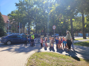 na zdjęciu są policjanci i dzieci przechodzący przez jezdnię