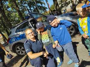 na zdjęciu są policjanci i dzieci przechodzący przez jezdnię