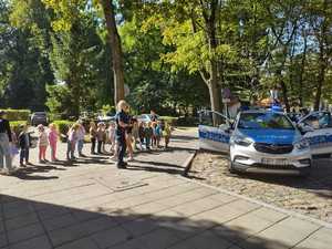 na zdjęciu są policjanci i dzieci przechodzący przez jezdnię