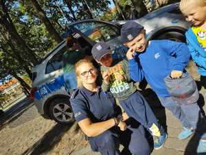 na zdjęciu są policjanci i dzieci przechodzący przez jezdnię