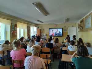 na zdjęciu widoczni są uczniowie i ich rodzice oraz policjant