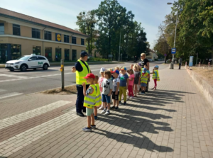 na zdjęciu widoczni są policjanci umundurowani oraz dzieci biorące udział w spotkaniu